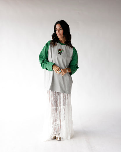 Gray and green raglan long sleeve tee with small mascot graphic on chest