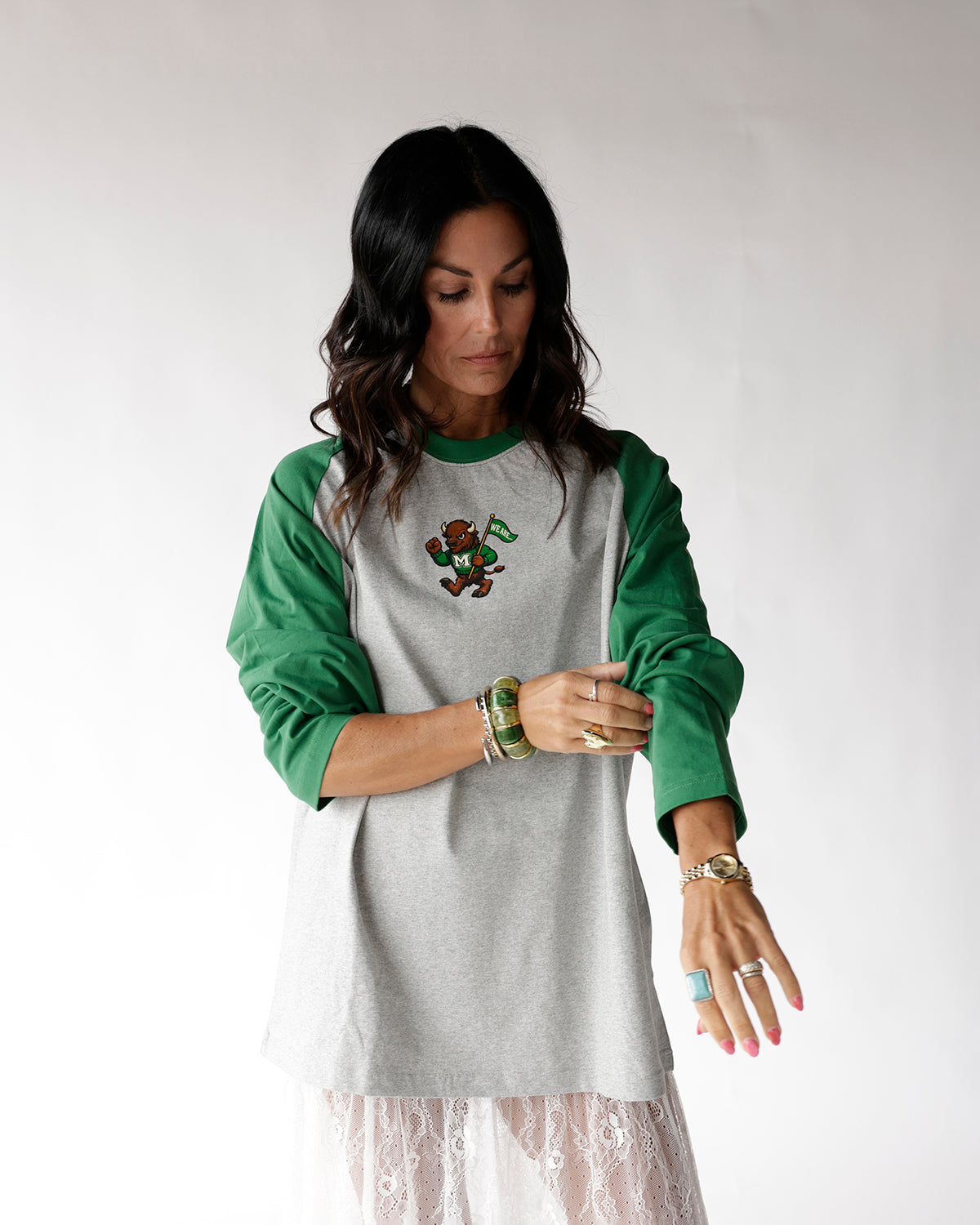 Gray and green raglan long sleeve tee with mascot graphic, worn by woman