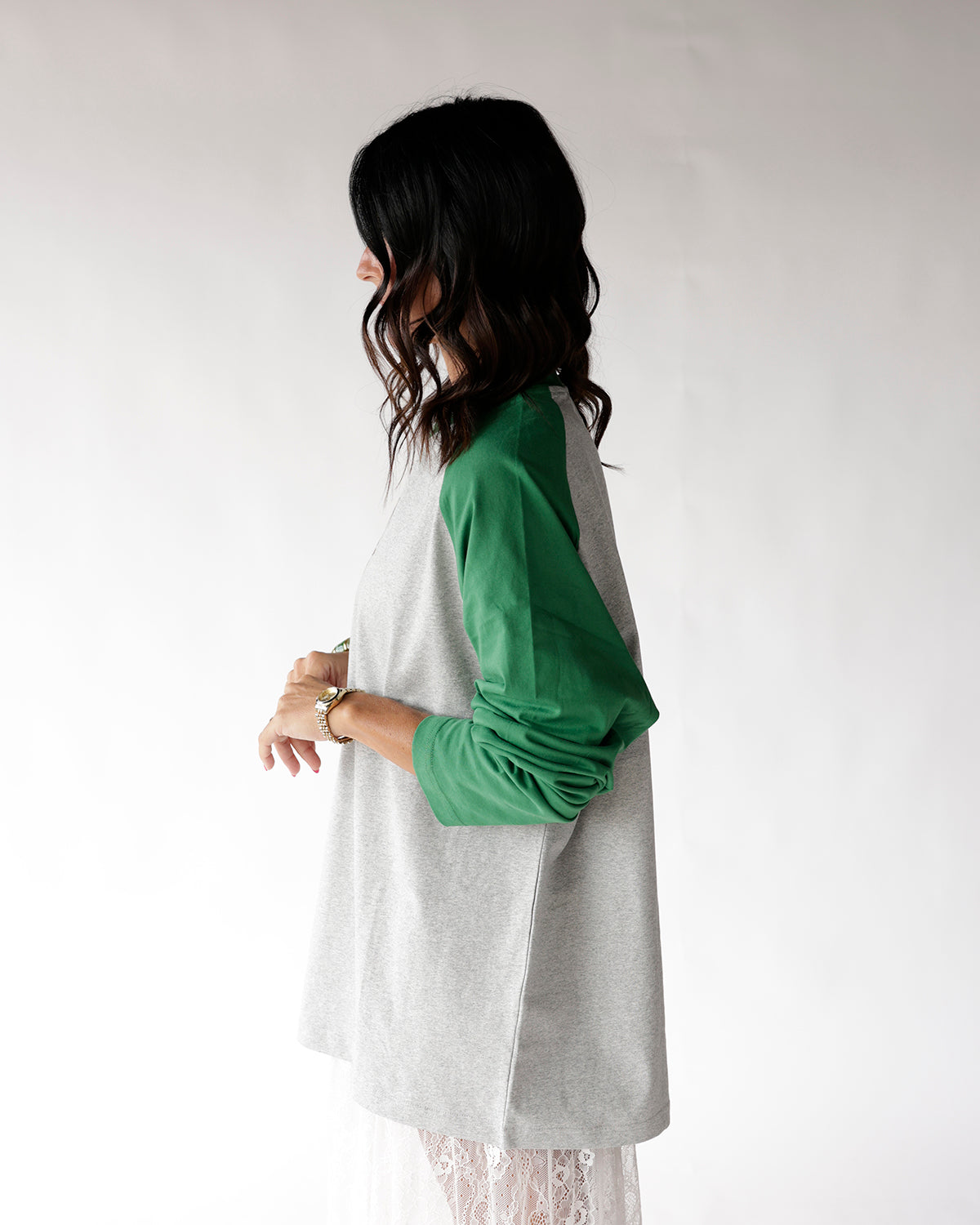 Gray and green raglan long sleeve tee, side view on dark-haired model