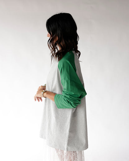 Gray and green raglan long sleeve tee, side view on dark-haired model