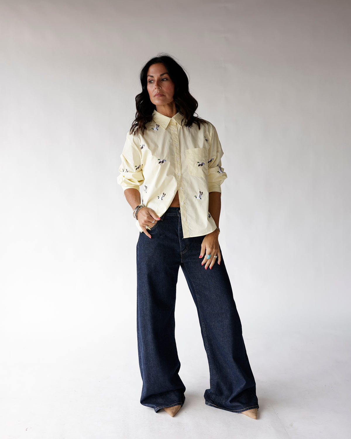 Light yellow button-up shirt with small duck print, worn with wide-leg dark jeans