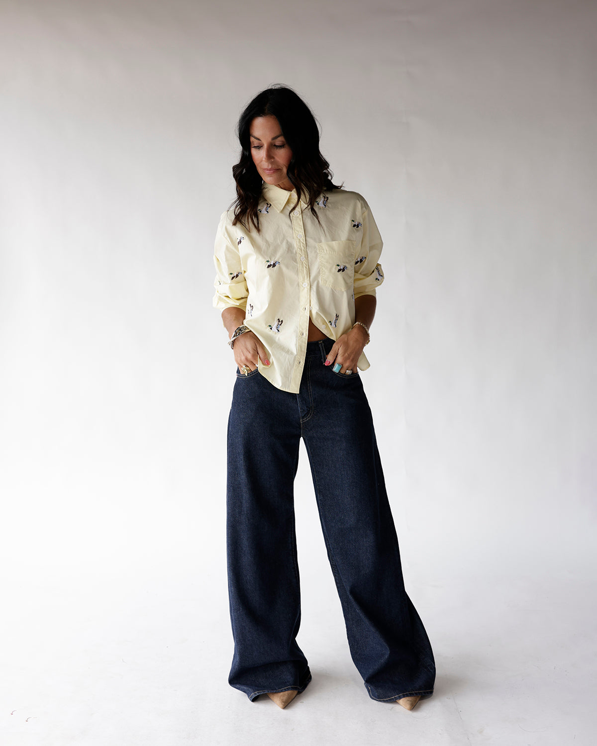 Light yellow button-up shirt with small duck print, worn with wide-leg dark jeans