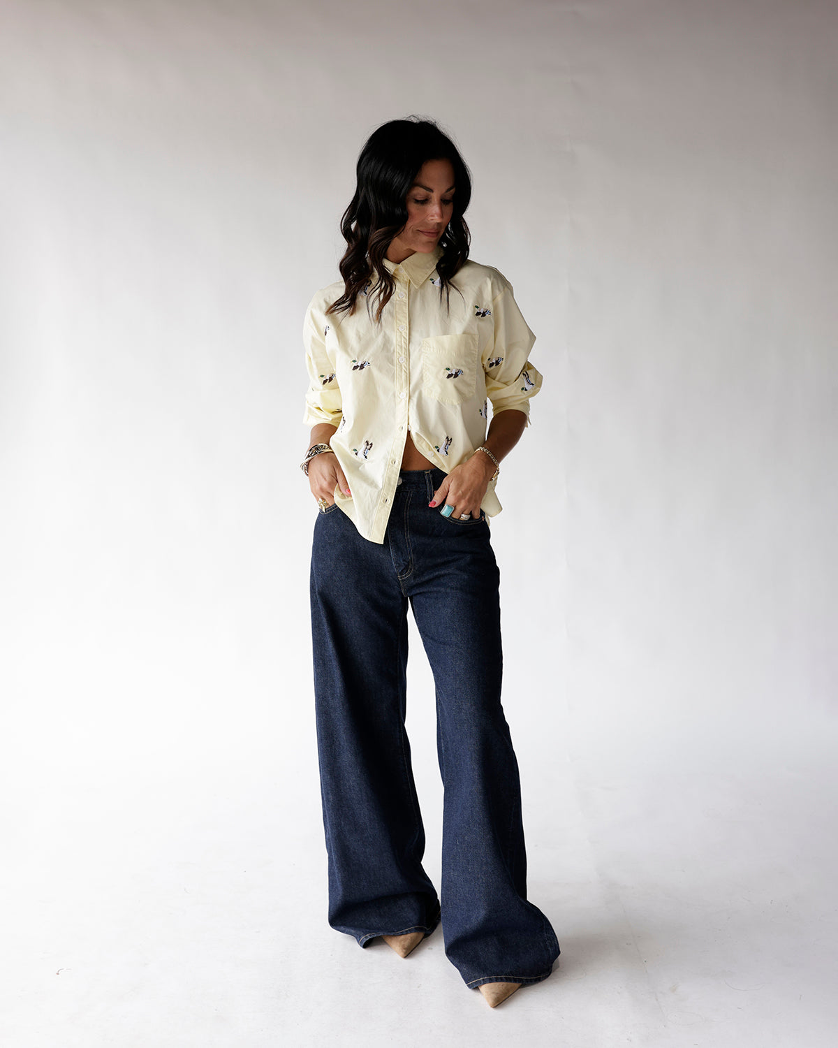 Light yellow button-up shirt with small duck print, worn with wide-leg dark jeans