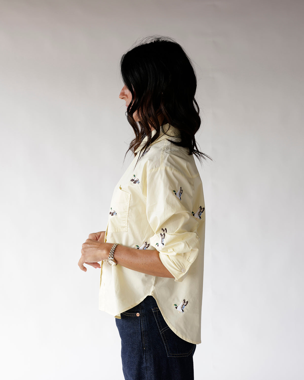 Light yellow button-up shirt with duck print, rolled sleeves, worn with dark jeans