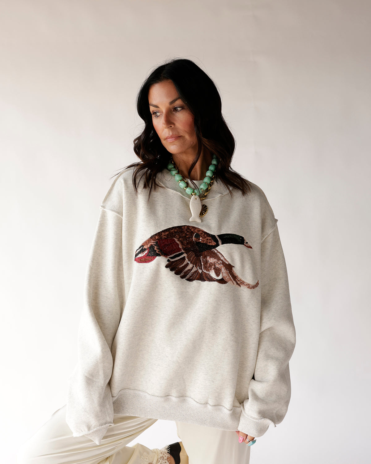 Oversized cream mock neck sweatshirt with mallard duck graphic on chest