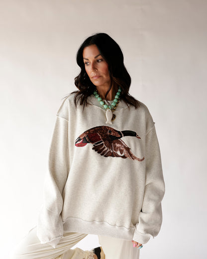 Oversized cream mock neck sweatshirt with mallard duck graphic on chest