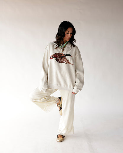 Oversized cream mock neck sweatshirt with flying mallard duck graphic print