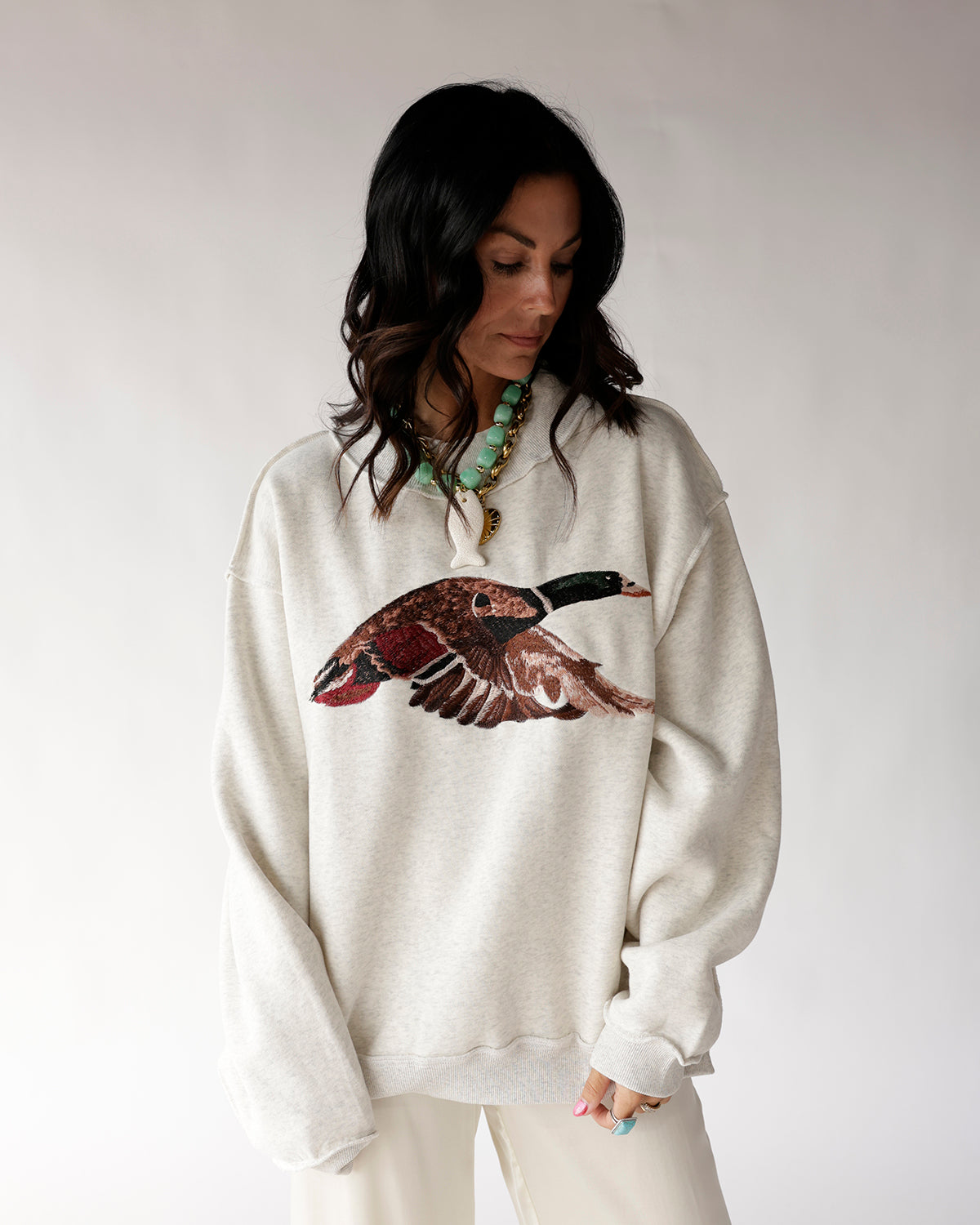 Oversized cream mock neck sweatshirt with flying mallard duck graphic print