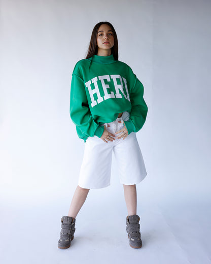 White wide-leg denim bermuda shorts, knee-length, high-rise, worn with green sweatshirt