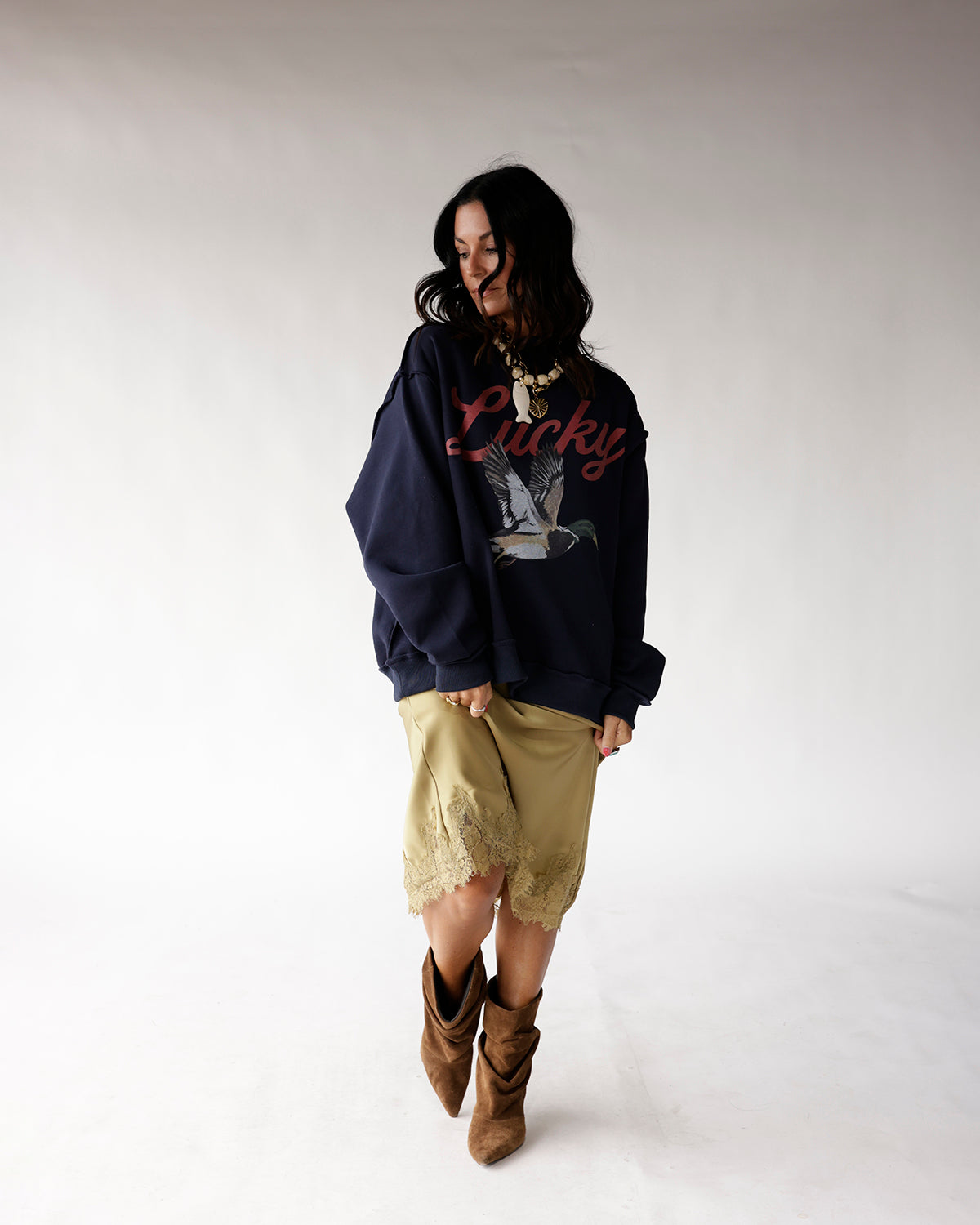 Oversized navy sweatshirt with Lucky script and mallard duck graphic, worn with satin skirt