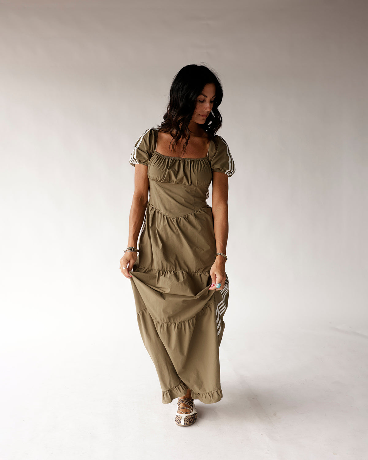 Olive green tiered maxi dress with puff sleeves and stripe trim details