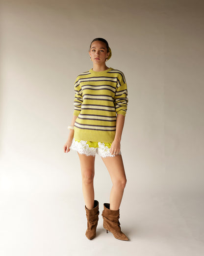 Chartreuse striped knit sweater worn with lace-trim shorts and brown suede boots