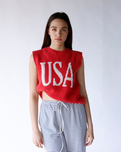 Red knit sleeveless sweater vest with white USA lettering, cropped fit
