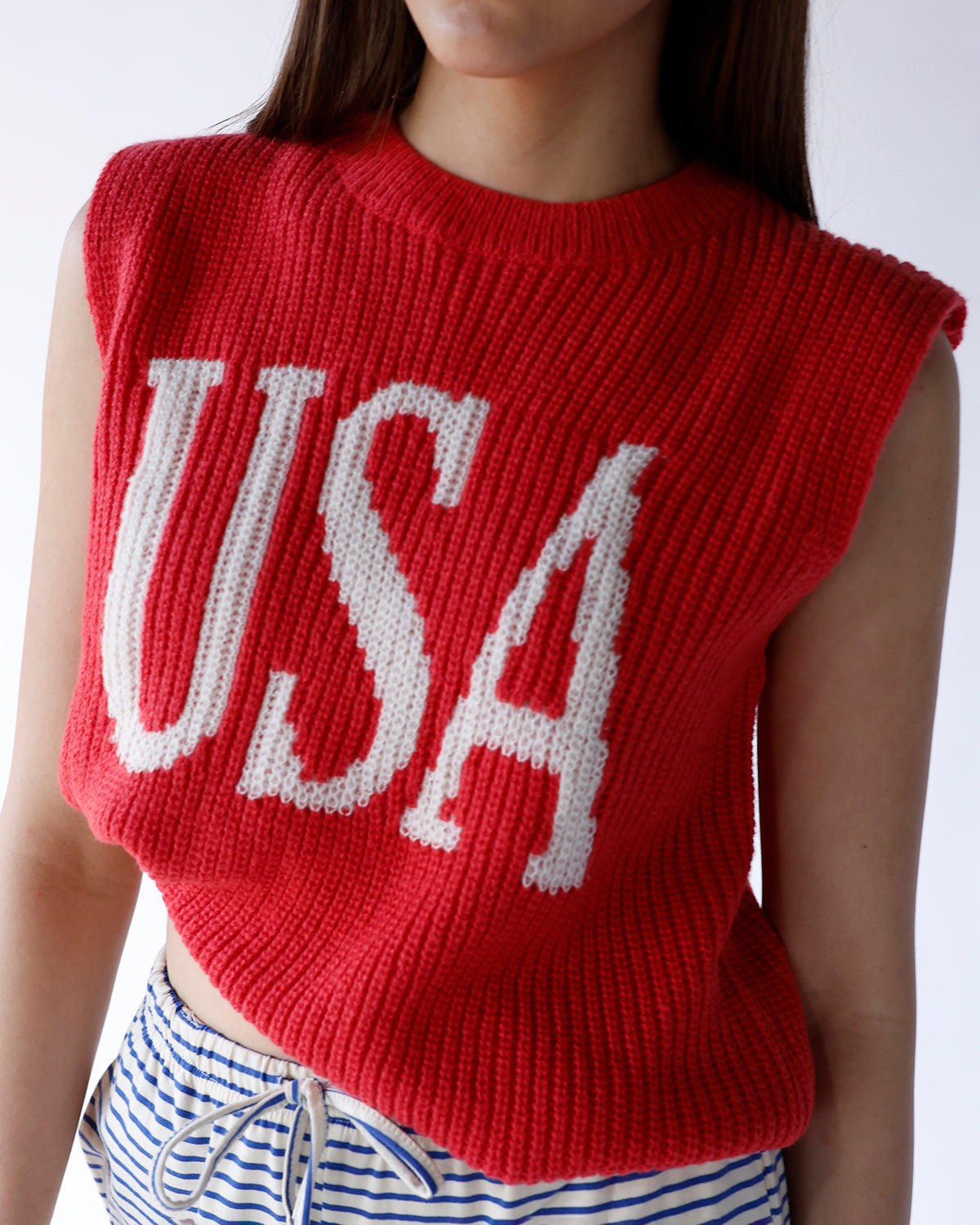 Red chunky knit sleeveless sweater vest with large white USA intarsia lettering