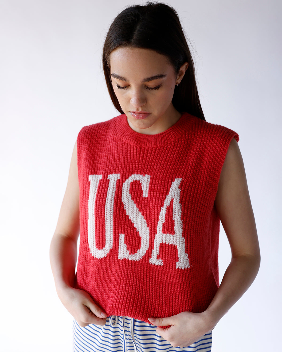 Red chunky knit sleeveless sweater vest with white USA lettering on front