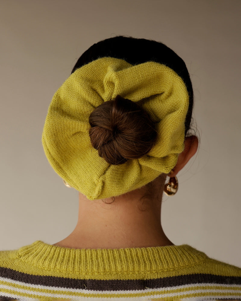 Chartreuse knit beret worn with matching striped sweater, hair bun visible through hat opening