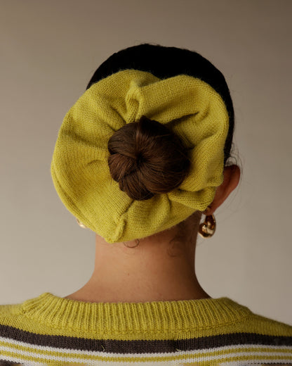 Chartreuse knit beret worn with matching striped sweater, hair bun visible through hat opening