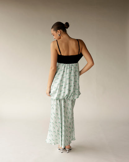 White floral maxi dress with black spaghetti strap bodice, worn with silver heels