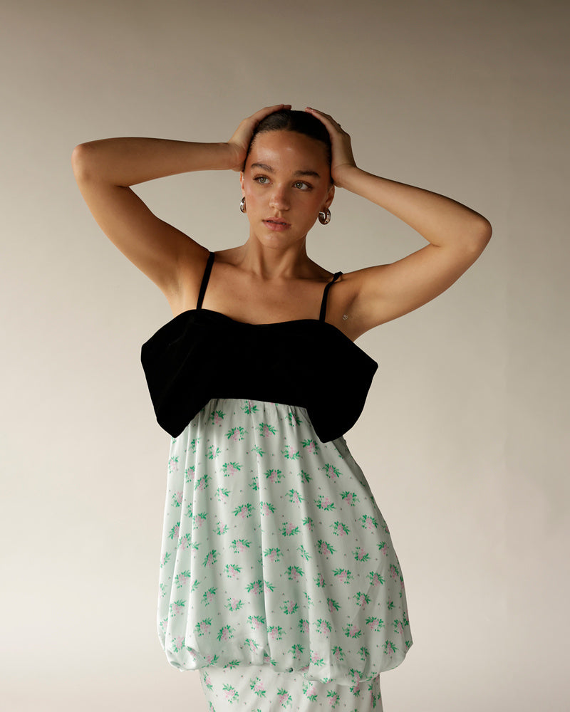 Black bodice floral mini dress with white green pink bubble hem on model