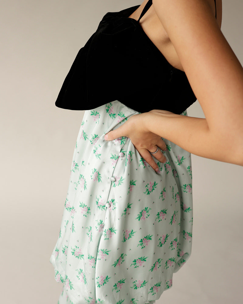 White floral mini skirt with pink green print and button detail, styled with black top