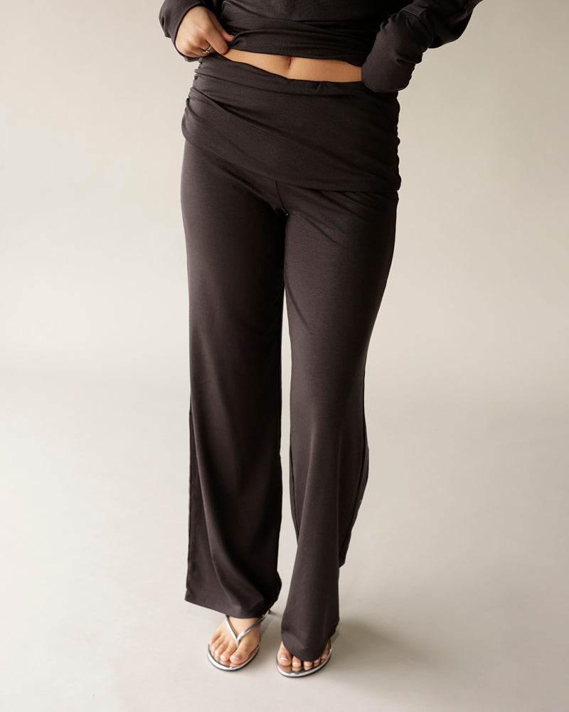 Dark brown wide-leg foldover waist pants worn with silver flip flops