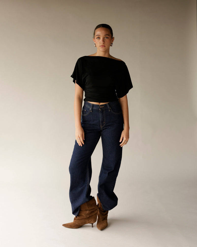Dark indigo wide-leg high-rise denim pants styled with black top and brown boots