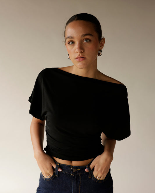 Dark wash high-waist jeans worn with black off-shoulder crop top