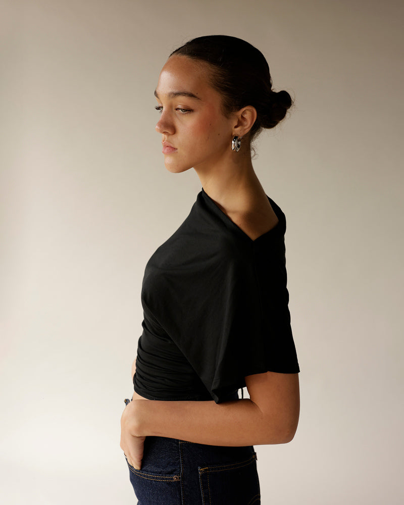 Dark navy blue dressy pants worn with black top, side profile view