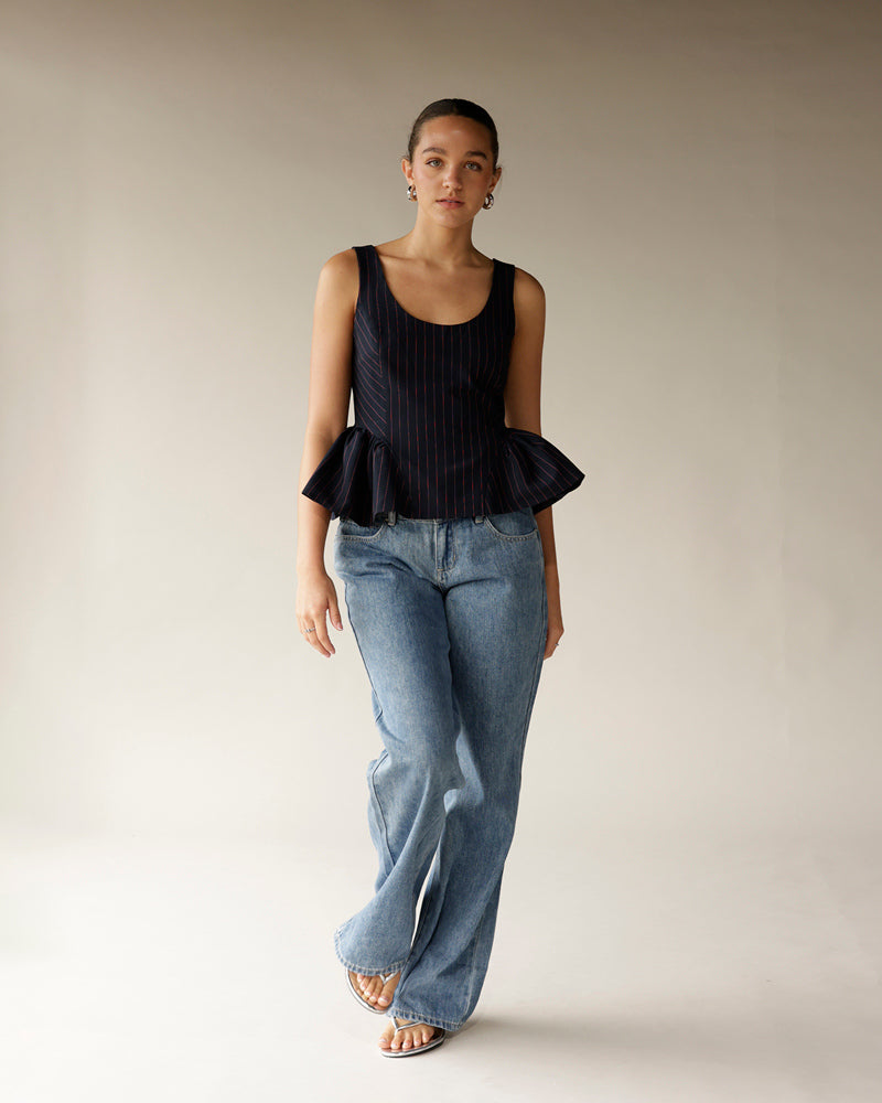 Light wash wide-leg denim jeans styled with a navy pinstripe peplum top and sandals