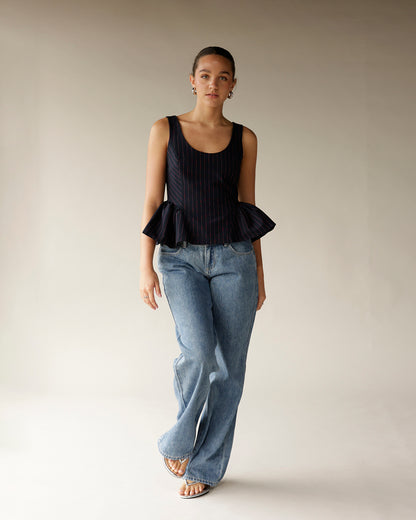 Light wash wide-leg denim jeans styled with a navy pinstripe peplum top and sandals