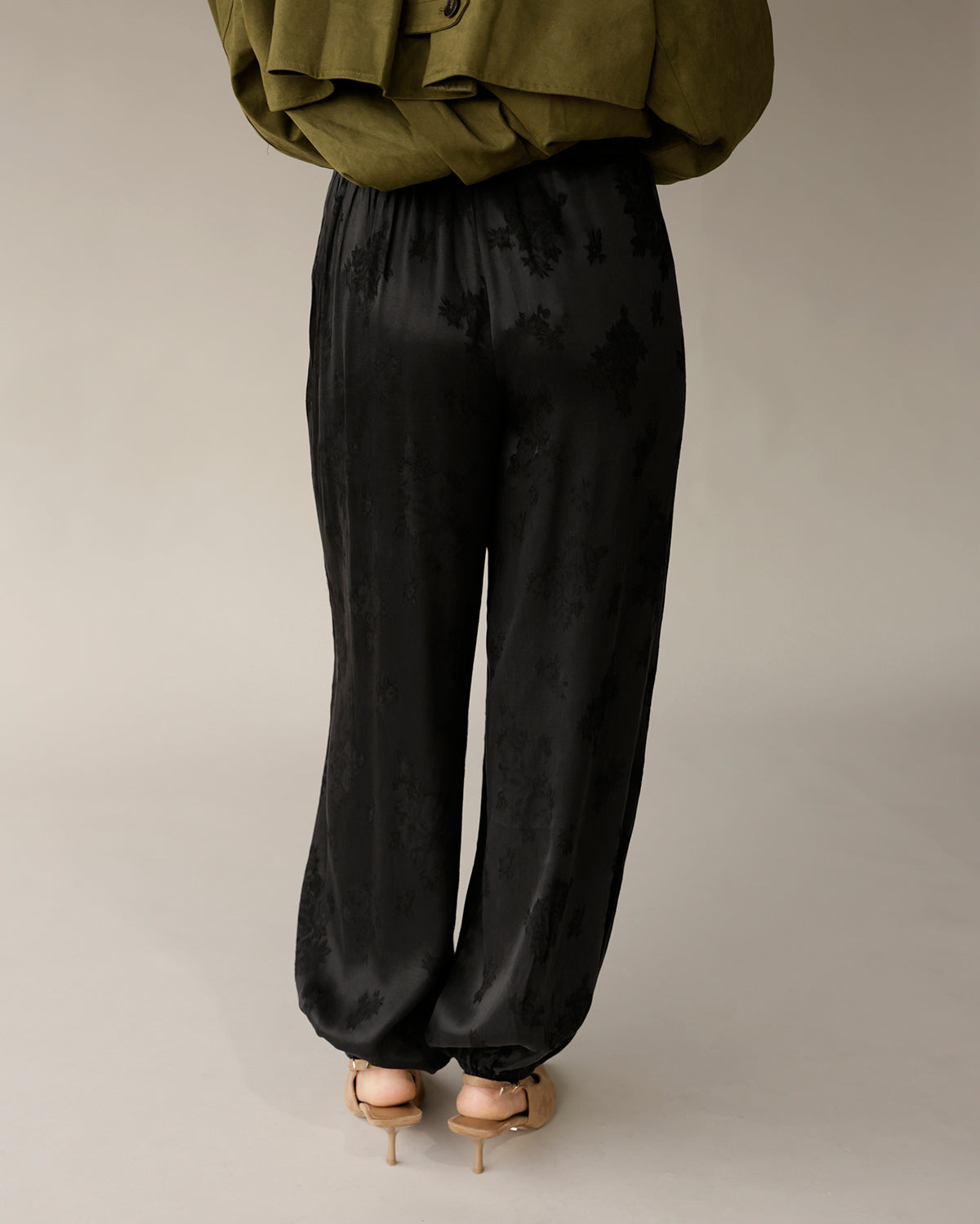 Black satin jacquard floral balloon pants with elastic waist and cuffed ankles