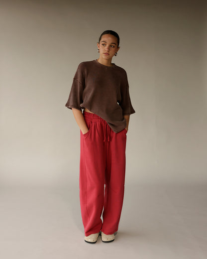 Brown ribbed oversized short-sleeve crew neck tee worn with red wide-leg pants