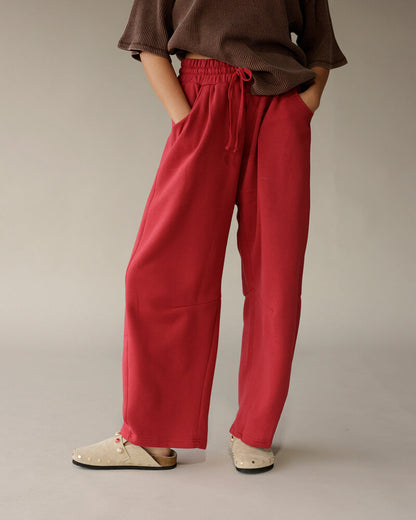 Model wearing brown ribbed oversized tee with wide-leg red drawstring pants and beige clogs