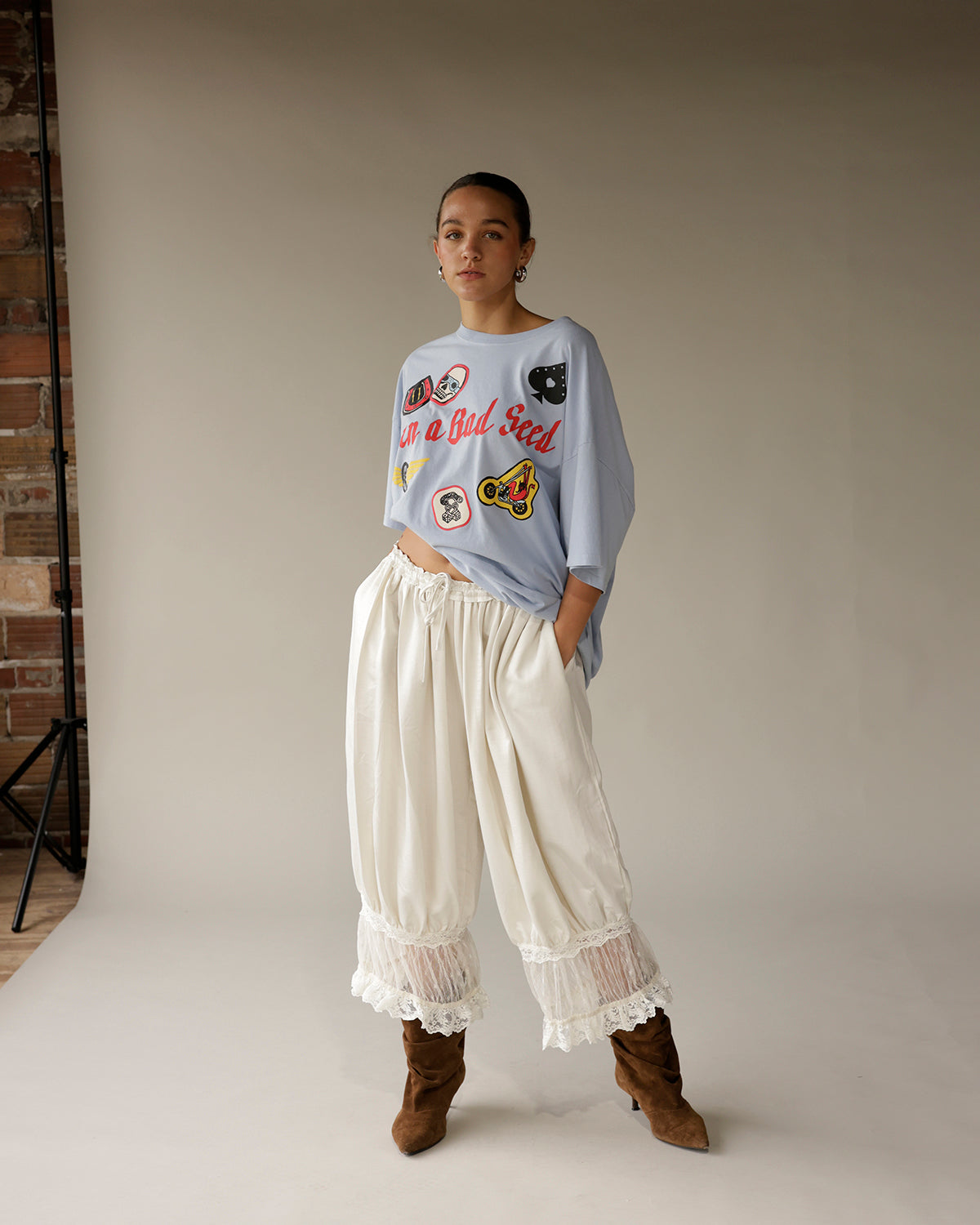 Cream satin wide-leg pants with lace trim hem and gathered waist detail
