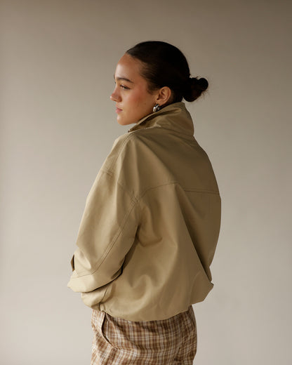 Women's oversized beige zip-up jacket with high collar, back view