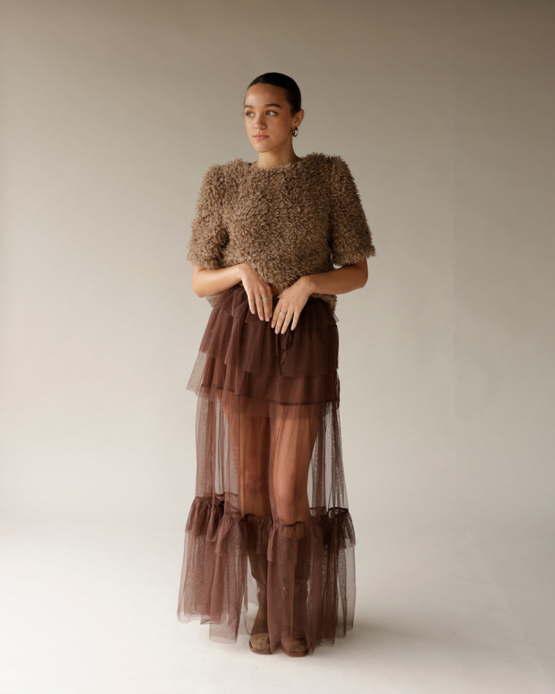Women's brown fuzzy textured cropped sweater with short sleeves, worn with tulle skirt