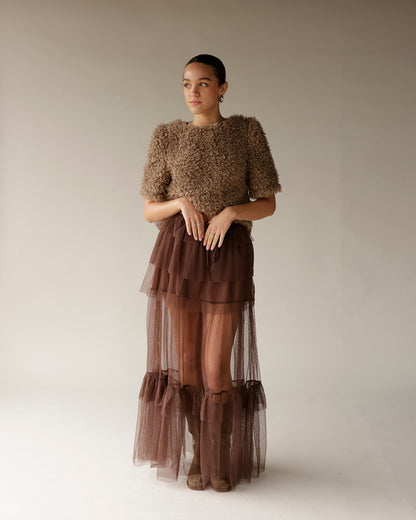 Women's brown fuzzy textured cropped sweater with short sleeves, worn with tulle skirt