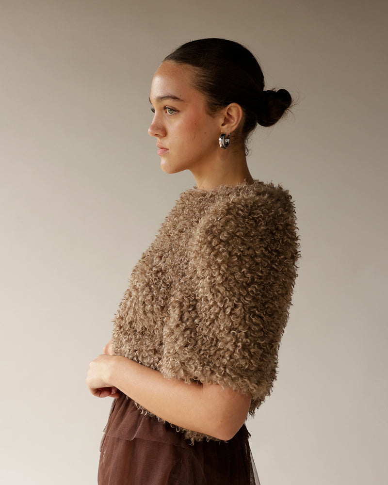 Women's taupe curly textured cropped sweater with short sleeves, worn with brown skirt