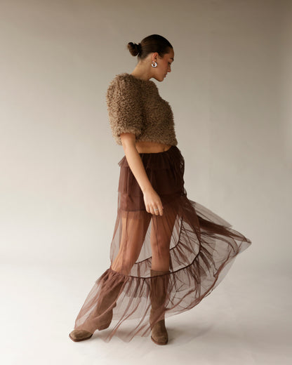 Women's tan fuzzy crop sweater with short sleeves, worn with brown tulle skirt