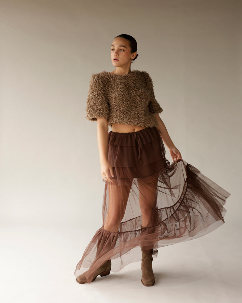 Women's brown fuzzy crop sweater with short sleeves, paired with sheer tulle skirt