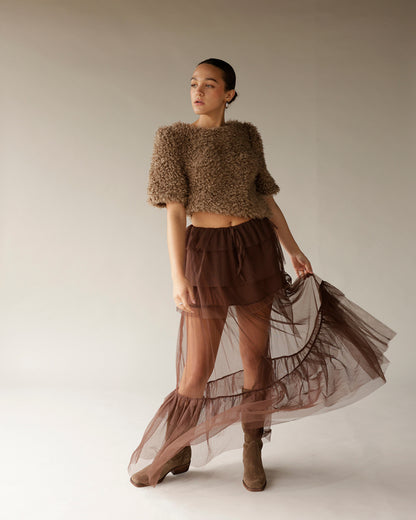 Women's brown fuzzy crop sweater with short sleeves, paired with sheer tulle skirt