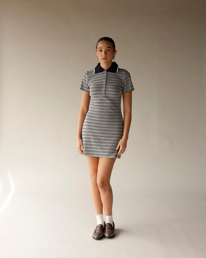 Gray striped polo mini dress with navy collar, short sleeves, and button placket