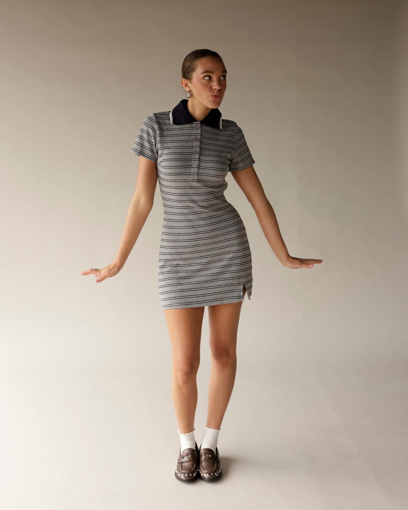 Gray striped polo mini dress with navy collar, short sleeves, and side slit