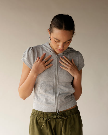 Soft gray short-sleeve hoodie featuring a trendy double-zip front and subtle puff sleeves. The perfect casual-chic layer for everyday styling.
