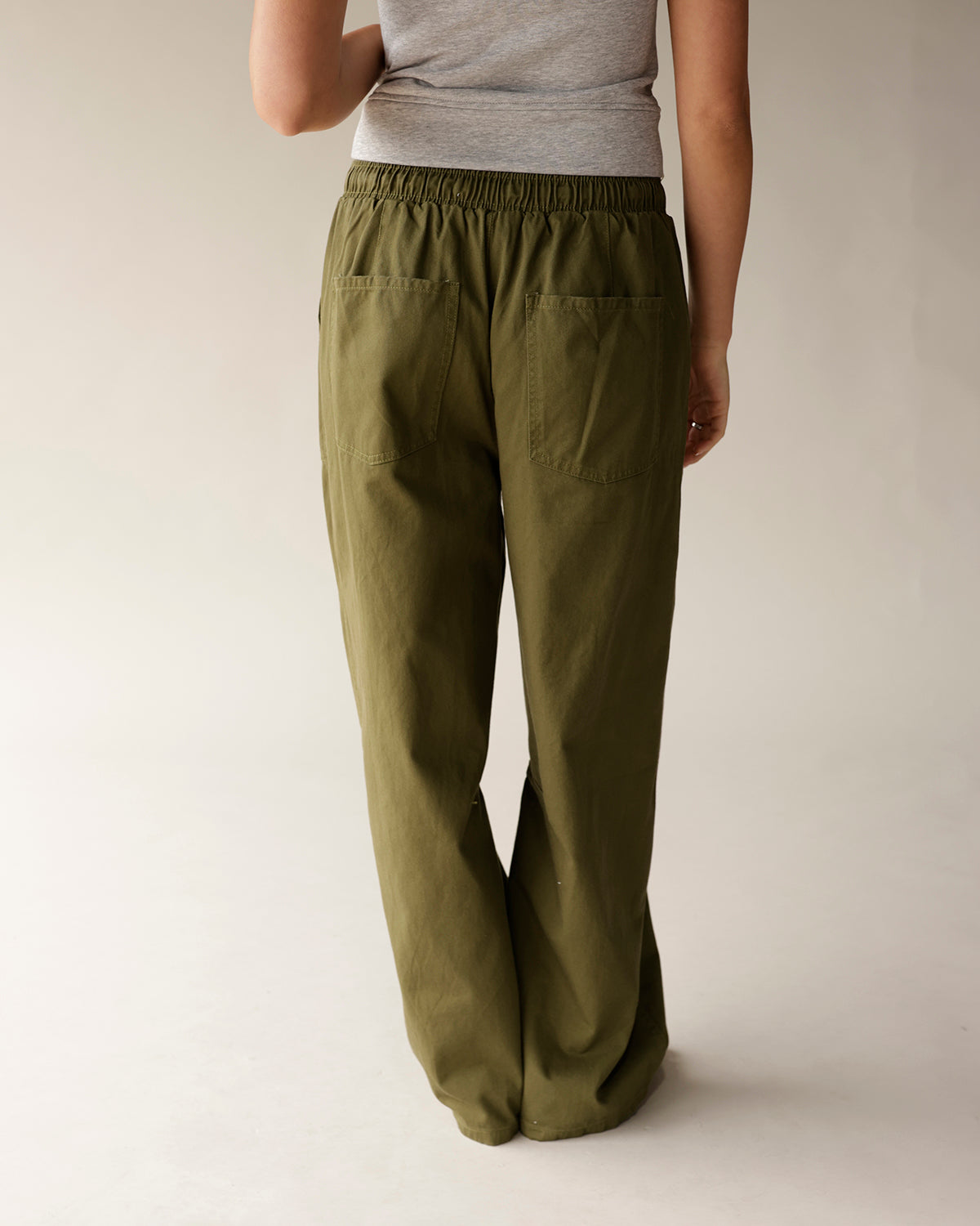 Women's olive green wide-leg cargo pants with elastic waist and back patch pockets