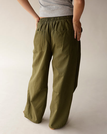 Olive green cargo barrel pants with elastic waist and patch pockets, back view