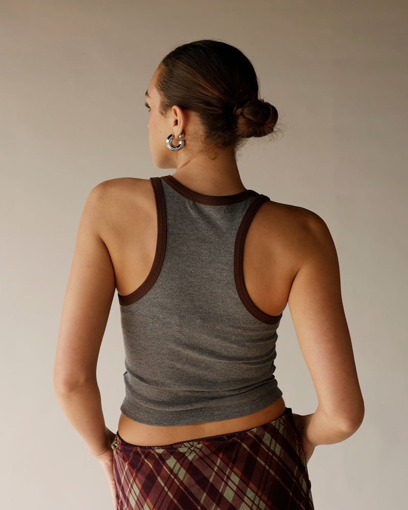Gray ribbed racerback tank top with brown contrast trim, worn with plaid skirt
