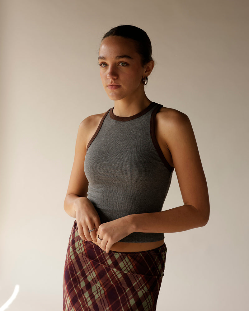 Gray ribbed racerback tank top with brown contrast trim, worn with plaid skirt