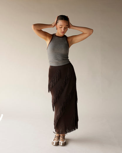 Dark brown midi fringe skirt with diagonal layered fringe detailing, worn with gray tank