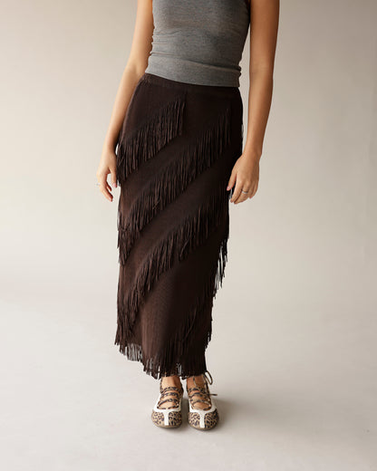 Dark brown diagonal fringe maxi skirt paired with gray tank top and leopard flats